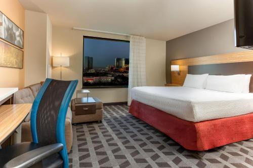 a hotel room with a bed and a large window at TownePlace Suites By Marriott Las Vegas Stadium District in Las Vegas