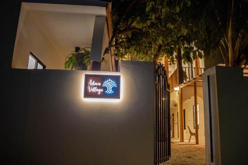 a sign on the side of a wall at night at Ahiva Village in Fulhadhoo