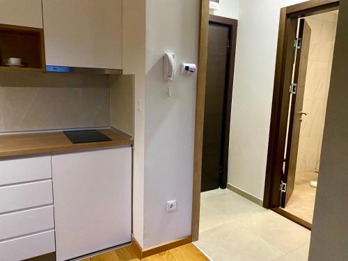 a small kitchen with a counter and a door at EVA apartman, Titova Vila, Zlatibor in Palisad