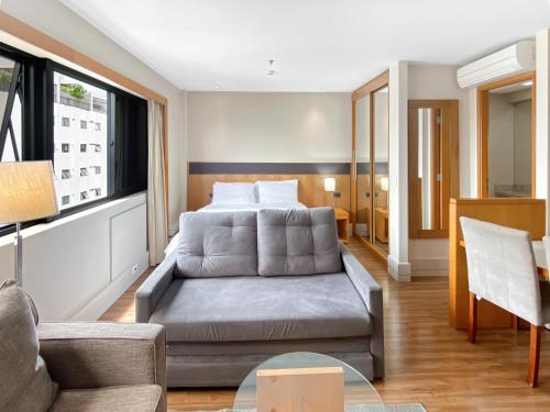 uma sala de estar com uma cama e um sofá em Hotel Corporativo na Faria Lima em São Paulo