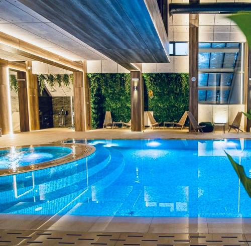 a large swimming pool in a hotel room with a large pool at EVA apartman, Titova Vila, Zlatibor in Palisad