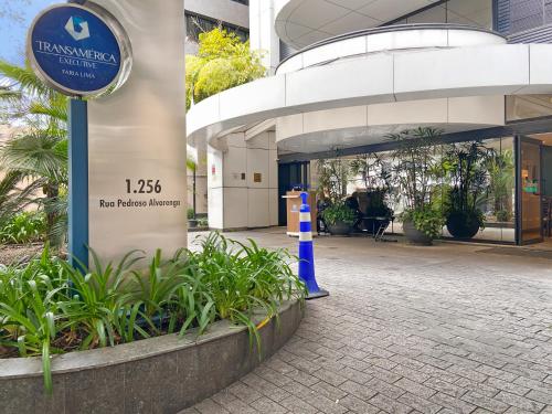 a sign in front of a building with plants at Hotel Corporativo na Faria Lima in Sao Paulo