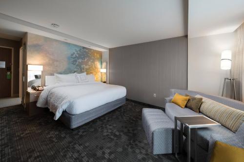 una camera d'albergo con letto e divano di Courtyard by Marriott Russellville a Russellville