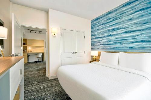a bedroom with a white bed and a blue painting on the wall at TownePlace Suites by Marriott Asheville West in Asheville