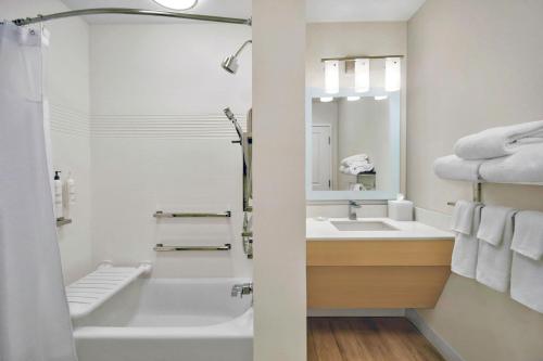 a bathroom with a tub and a sink and a mirror at TownePlace Suites by Marriott Asheville West in Asheville