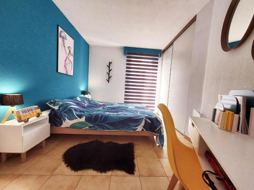 um quarto com uma cama e uma parede azul em Appartement à 100m de la plage 7 nuits minimum haute saison em Sainte-Maxime