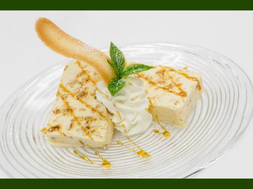 a plate with a piece of cake and whipped cream at Agriturismo Miravalle in Brusio