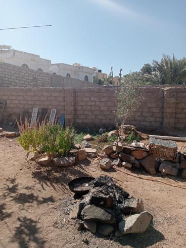 a backyard with a fire pit and a brick wall at Caravan Nights in desert in Dahab