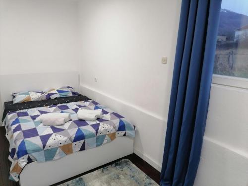 a small bedroom with a bed and a window at Villa Apartments B&D in Ohrid