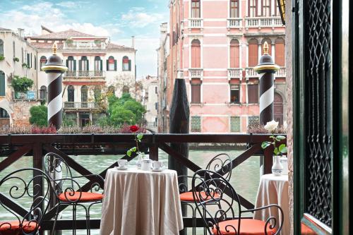 a balcony with tables and chairs with a view of the water at Residenza d'Epoca San Cassiano in Venice