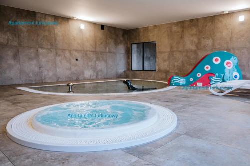 un jacuzzi dans une grande pièce avec un baignoireificial dans l'établissement Apartament Turkusowy - basen, sauna, klimatyzacja, à Dziwnów