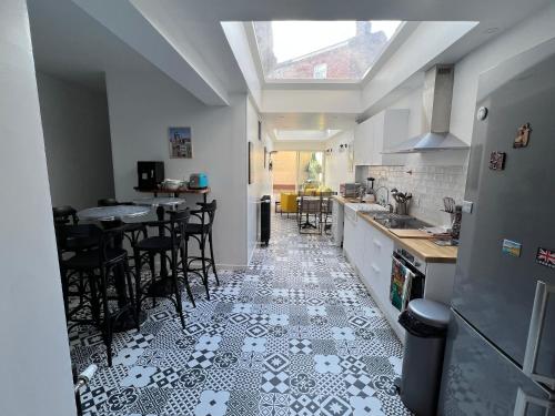Il comprend une cuisine dotée de carrelage noir et blanc. dans l'établissement La petite place de la Porte d'Arras, à Lille