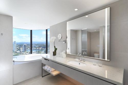 a bathroom with a large mirror and a tub and a sink at JW Marriott Gold Coast Resort & Spa in Gold Coast
