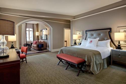 a bedroom with a large bed and a living room at The Algonquin Resort St. Andrews by-the-Sea, Autograph Collection in Saint Andrews