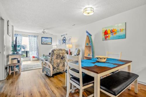 a dining room with a table and a surfboard on the wall at Lil River Paradise in Little River