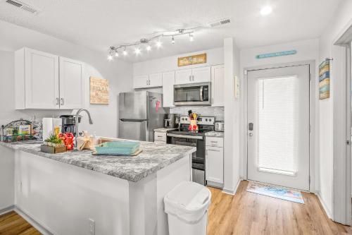 a kitchen with white cabinets and a granite counter top at Lil River Paradise in Little River