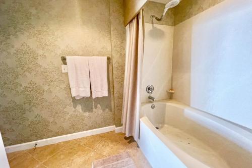 a bathroom with a tub and a towel on the wall at Sterling Reef 1407 in Panama City Beach