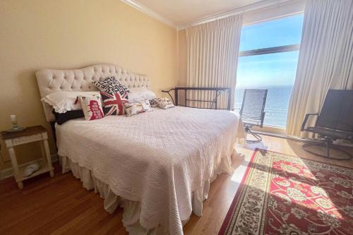 een slaapkamer met een wit bed en uitzicht op de oceaan bij Sterling Reef 1407 in Panama City Beach