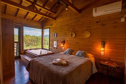 a bedroom with a large bed and a bath tub at Refúgio do Sol Campestre in Urubici