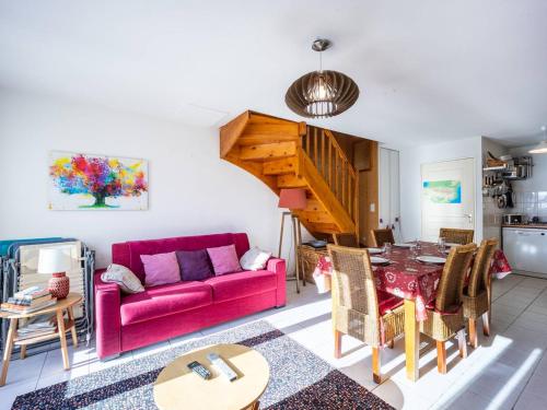 un salon avec un canapé rouge et une table dans l'établissement Appartement 8 personnes à Génos - Wifi, près du lac - FR-1-695-22, à Génos