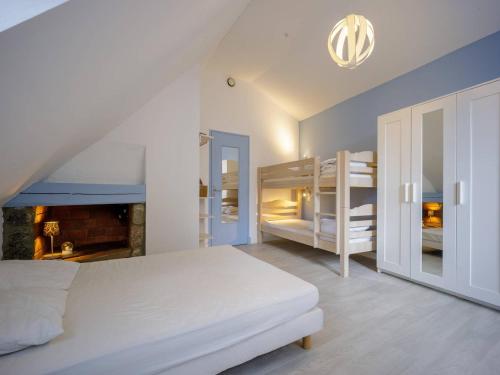 a bedroom with a bed and bunk beds and a fireplace at Maison Estarvielle, 5 pièces, 10 personnes - FR-1-695-25 