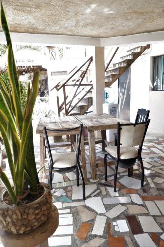 a dining room with a table and chairs and a plant at Casa Chi in Valladolid