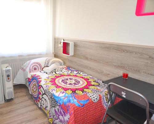 a bedroom with a bed with a colorful blanket on it at Mucho Madrid in Madrid