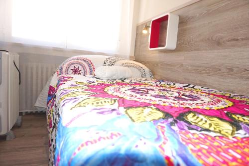 a bed with a colorful blanket on it in a room at Mucho Madrid in Madrid