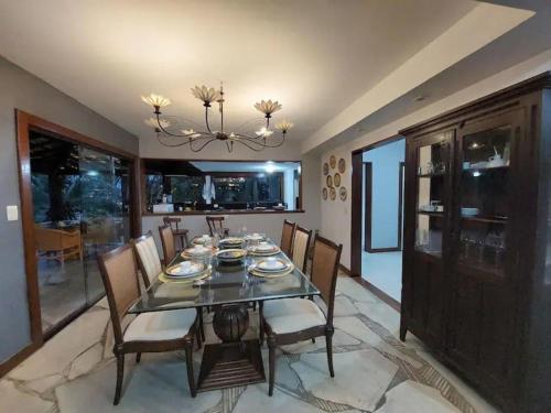 a dining room with a table with chairs and a chandelier at Casa Espetacular - João Fernandes - NÃO ACEITAMOS PETS in Búzios