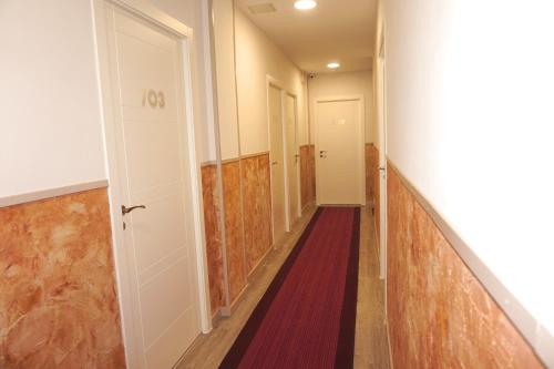 an empty hallway with a red carpet and a white door at Mucho Madrid in Madrid