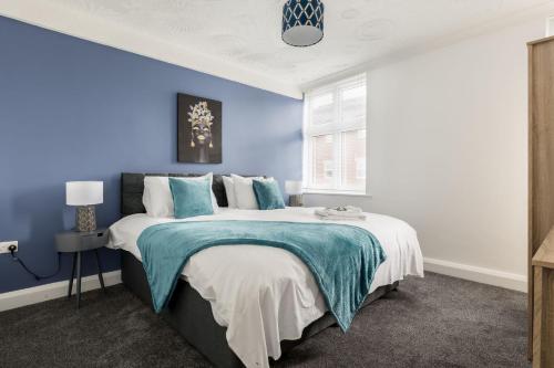 1 dormitorio con paredes azules y 1 cama grande en Lima Apartments Ltd-4 Beds-Large property -Long Stay Deal-Business-Parking en Bournemouth