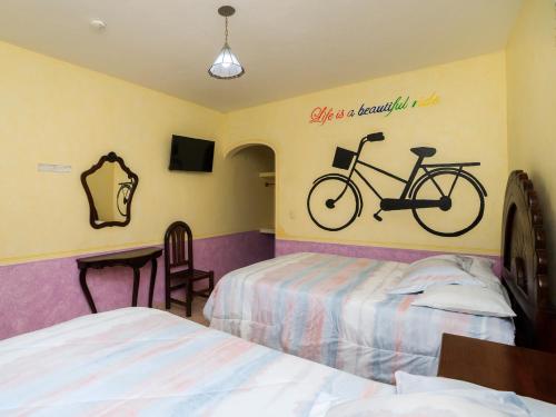 a bedroom with two beds and a bike on the wall at Hotel Quinta Mirador Zacualli in Bernal