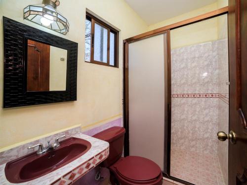 a bathroom with a sink and a toilet and a mirror at Hotel Quinta Mirador Zacualli in Bernal