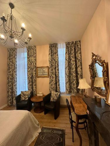 a bedroom with a bed and a desk and a mirror at B&B La Ducale in Ghent