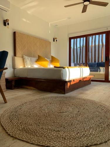 - une chambre avec un grand lit et un ventilateur de plafond dans l'établissement Luana Suites- Suite Aruma, à Zihuatanejo