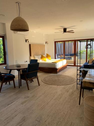 una camera da letto con un letto, un tavolo e delle sedie di Luana Suites- Suite Aruma a Zihuatanejo
