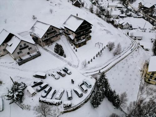 a group of cars parked in a parking lot covered in snow at Casa Victoria in Moieciu de Sus