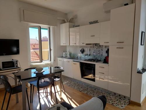 een keuken met witte kasten en een tafel met stoelen bij Casa Pamy- Bike Friendly 9029LT1161 in Finale Ligure