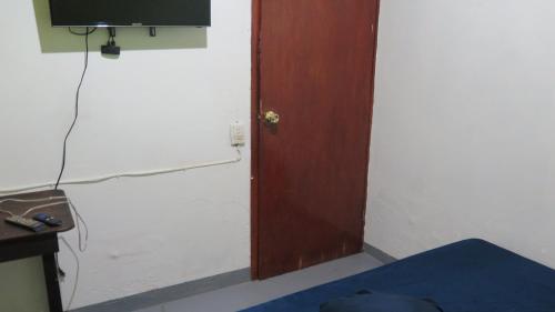 a room with a door and a tv on a wall at Posada María Elvia in Villahermosa