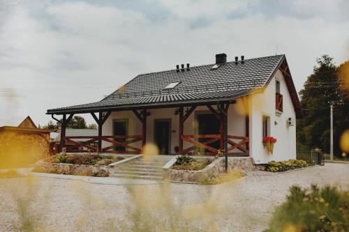 a small house with a black roof at Pasieka Podlaska Tradycja in Siemiatycze