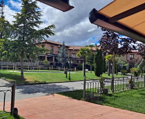 a park with a building and trees and a sidewalk at Palacio del Conde de Rebolledo in Villaviciosa de la Ribera