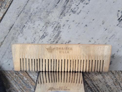 a wooden comb sitting on top of a table at Dhairya's Villa Home Away From Home in Jammu