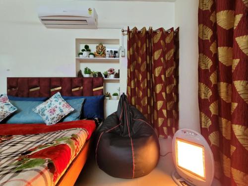 a room with a bed and a television and curtains at Dhairya's Villa Home Away From Home in Jammu
