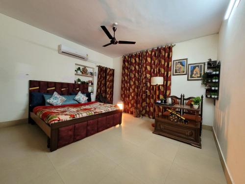 a bedroom with a bed and a ceiling fan at Dhairya's Villa Home Away From Home in Jammu