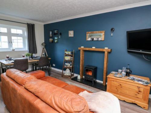 a living room with a couch and a fire place at Ty Rhys in Cardigan