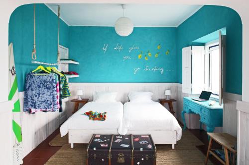 a bedroom with a bed and a blue wall at Chill in Ericeira Surf House in Ericeira