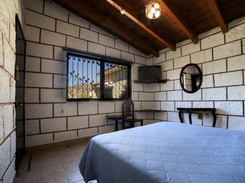 a bedroom with a bed and a window at Hotel Quinta Mirador Zacualli in Bernal