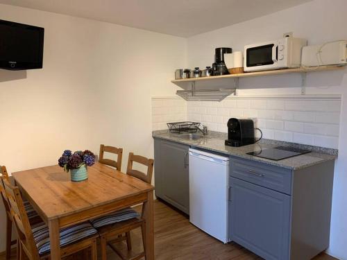 une cuisine avec une table en bois et une cuisine avec une table et des chaises dans l'établissement Lugar do Curro, San Martiño de Ozón, à Muxía