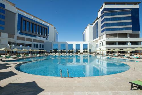 a large swimming pool in front of a building at Tolip Olympic International City in New cairo