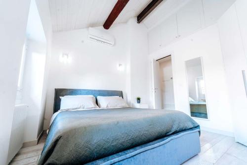 a bedroom with a blue bed in a white room at Loft Cavour - Teatro Ariston in Sanremo